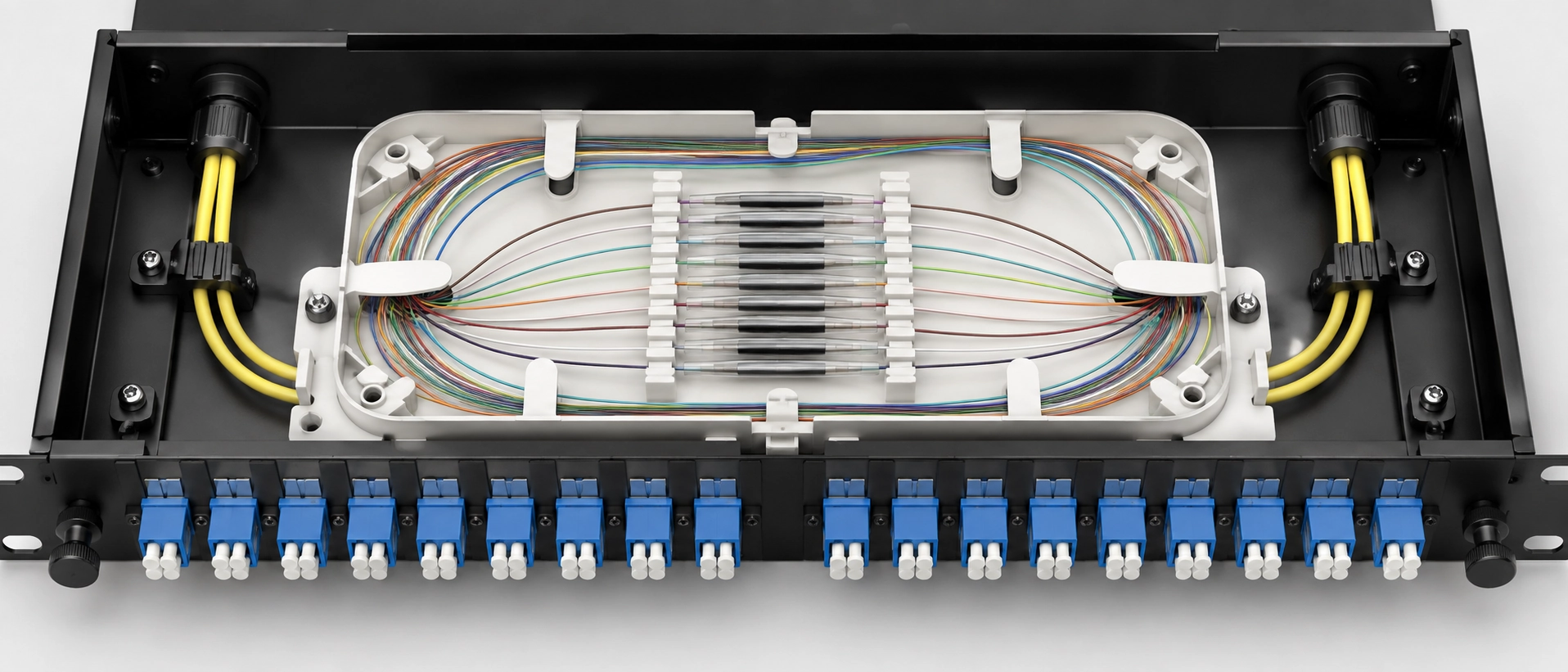 Fiber pigtail fusion splicing inside a patch panel splice tray showing organized fiber loops and heat shrink sleeve holders